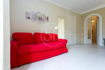 a red couch sitting in a living room at Apartamento céntrico para 4 in Barcelona