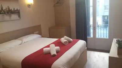 a bedroom with a bed with towels on it at Hostal Barcelona Travel in Barcelona