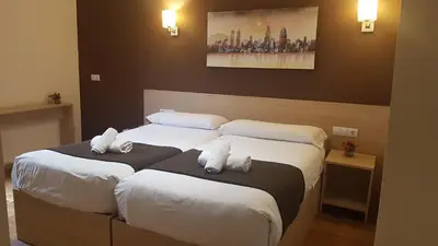 two beds in a hotel room with white pillows at Hostal Barcelona Travel in Barcelona