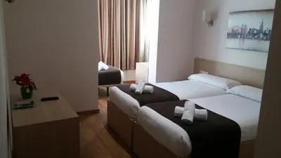 a hotel room with two beds and a couch at Hostal Barcelona Travel in Barcelona