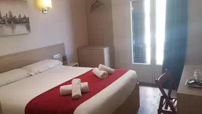 a bedroom with a bed with two towels on it at Hostal Barcelona Travel in Barcelona