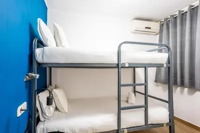 a white bedroom with two beds and a window at The Collection Barcelona - Eixample 4BD 2BTh with private Terrace in Barcelona