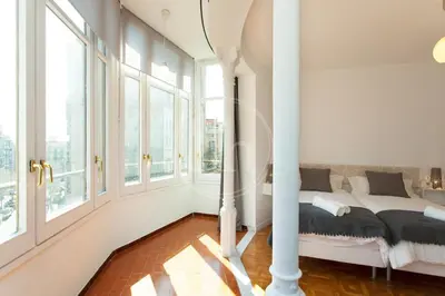 a bedroom with a bed and large windows at Céntrico apartamento familiar in Barcelona