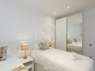 a bedroom with two beds and a mirror at Nice apartment on Valencia Street in Barcelona