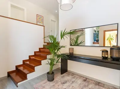 a living room with a staircase and a mirror at Villa Llum with Views, Pool 25 minutes from BCN in Alella