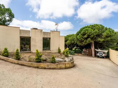 a building with a tree in front of it at Villa Llum with Views, Pool 25 minutes from BCN in Alella