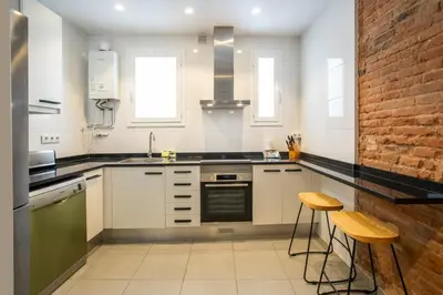 a kitchen with white cabinets and a brick wall at 21MAL1089-Magnific apartment near Sagrada familia in Barcelona