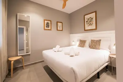 a bedroom with a large white bed and a mirror at 21MAL1089-Magnific apartment near Sagrada familia in Barcelona