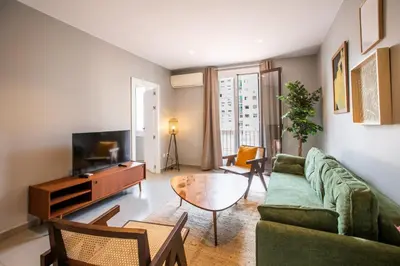 a living room with a green couch and a tv at 21MAL1089-Magnific apartment near Sagrada familia in Barcelona