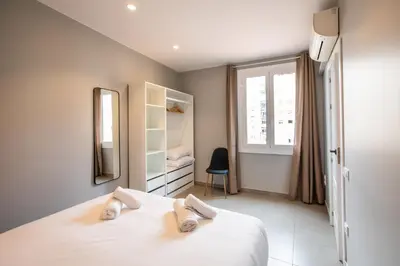 a bedroom with a bed and a mirror and a window at 21MAL1089-Magnific apartment near Sagrada familia in Barcelona