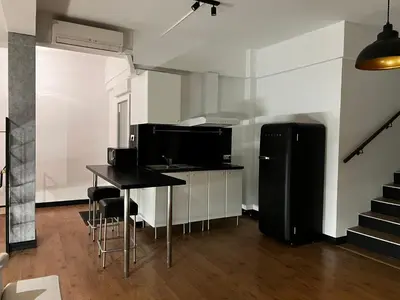 a kitchen with a black refrigerator and a table at Loft en Gracia in Barcelona