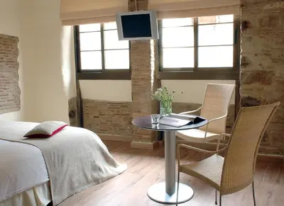 a bedroom with a bed and a table and chairs at AinB Picasso-Corders Apartments in Barcelona