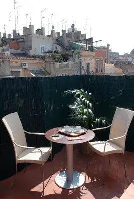 a table and chairs on a balcony with a view of a city at AinB Picasso-Corders Apartments in Barcelona