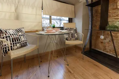 a table and chairs in a room with a window at AinB Picasso-Corders Apartments in Barcelona