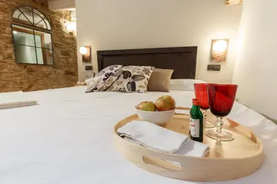 a tray with two glasses and a bottle of wine on a bed at AinB Picasso-Corders Apartments in Barcelona