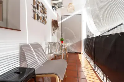 a balcony with chairs and a table and a window at Bonito apartamento en l'Eixample in Barcelona