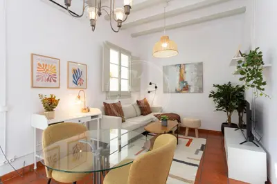 a living room with a glass table and chairs at Bonito apartamento en l'Eixample in Barcelona