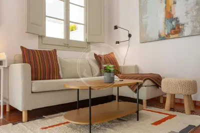 a living room with a couch and a table at Bonito apartamento en l'Eixample in Barcelona