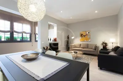 a living room with a television and a table and chairs at Modern Eixample Apartment in Barcelona