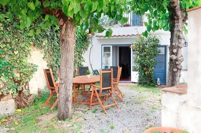 a wooden table and two chairs on a patio at Charming house in Sant Pol facing the sea in San Pol de Mar