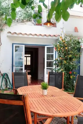 a wooden table and chairs under a tree at Charming house in Sant Pol facing the sea in San Pol de Mar