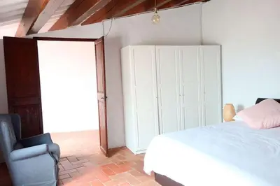 a bedroom with a white bed and a chair at Charming house in Sant Pol facing the sea in San Pol de Mar