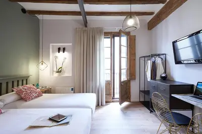 a bedroom with a bed and a tv and a couch at AinB Gothic-Jaume I Apartments in Barcelona