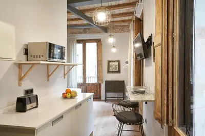 a kitchen with white cabinets and a counter top at AinB Gothic-Jaume I Apartments in Barcelona