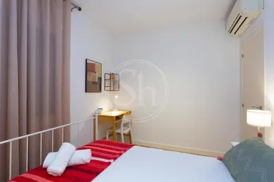 a bedroom with a bed with red and white sheets at Bonito apartamento cerca de la Sagrada Familia in Barcelona