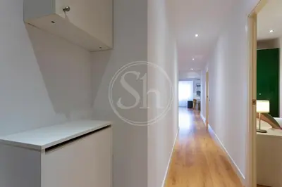 a hallway with white walls and a white counter top at Bonito apartamento cerca de la Sagrada Familia in Barcelona