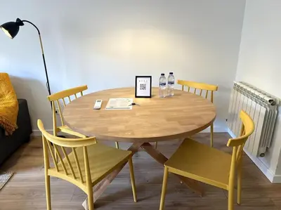 a wooden table with two chairs and a lamp at Apartamento entero con patio en Terrassa, Barcelona in Terrassa