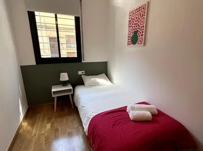 a small bedroom with a bed and a window at Apartamento entero con patio en Terrassa, Barcelona in Terrassa