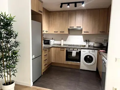a kitchen with a washing machine and a washer at Apartamento entero con patio en Terrassa, Barcelona in Terrassa