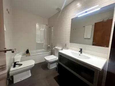 a white bathroom with a toilet and a sink at Apartamento entero con patio en Terrassa, Barcelona in Terrassa