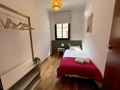 a bedroom with a bed with a red blanket at Apartamento entero con patio en Terrassa, Barcelona in Terrassa