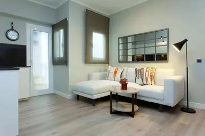 a living room with a white couch and a tv at Bonito apartamento para 2 in Barcelona