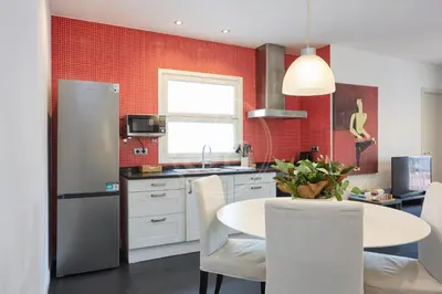 a kitchen and living room with red tile at Bonito apartamento con terraza in Barcelona