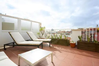 a patio with a table and chairs on a balcony at Bonito apartamento con terraza in Barcelona
