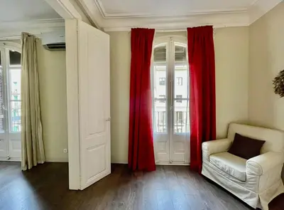 a living room with red curtains and a chair at BarcelonaForRent The Central Place in Barcelona