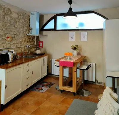 a kitchen with a table and a sink and a window at La Julita in San Quírico Safaja