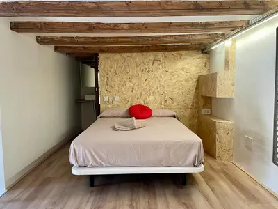 a bedroom with a bed with a red pillow on it at Barcelona Classic Plaza Real Apartments in Barcelona