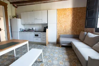 a living room with a couch and a kitchen at Barcelona Classic Plaza Real Apartments in Barcelona