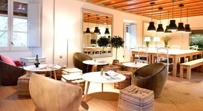 a restaurant with tables and chairs and a dining room at Hotel Can Carol in Capellades