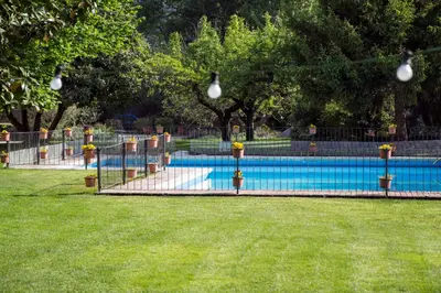 a swimming pool in a park with a fence at Hotel Can Carol in Capellades