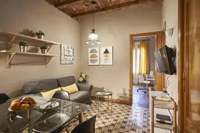 a living room with a couch and a glass table at BeBarceloner Sants Apartments- 3 bedroom in Barcelona