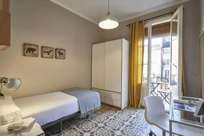 a hotel room with a bed and a balcony at BeBarceloner Sants Apartments- 3 bedroom in Barcelona