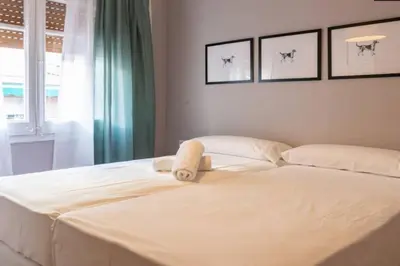 a white bed with a towel sitting on top of it at BeBarceloner Vall Hebron Apartment in Barcelona