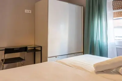 a bedroom with a white bed and a window at BeBarceloner Vall Hebron Apartment in Barcelona
