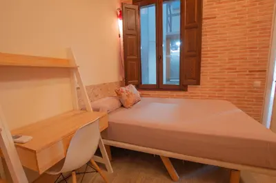 a small room with a bed and a desk at Barcelona Classic Catedral Apartments in Barcelona