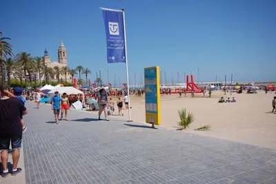 a crowd of people walking on a beach at Sitges rooms by Sitges Apartment in Sitges